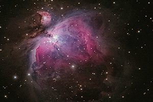 Image of outer space with bright pink nebulas,stars, and planets